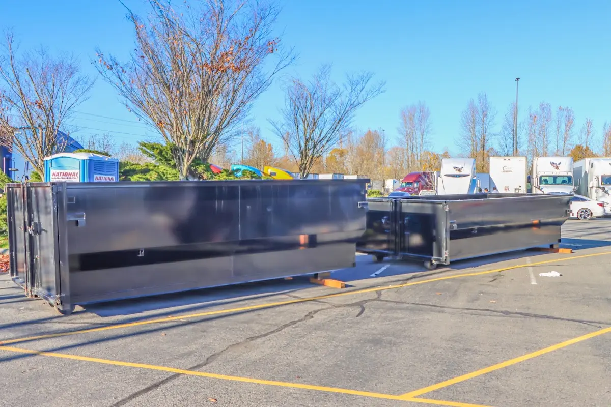 Professional dumpster rental service with roll-off container on residential driveway in Frederick